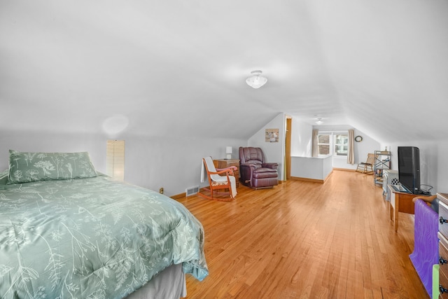 bedroom with hardwood / wood-style flooring and lofted ceiling