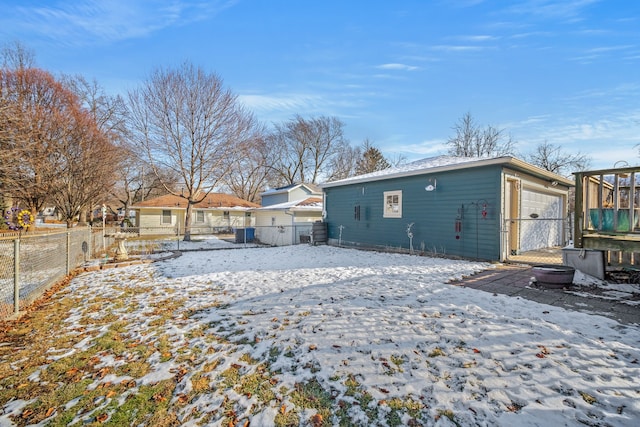 snow covered property with a garage and central air condition unit