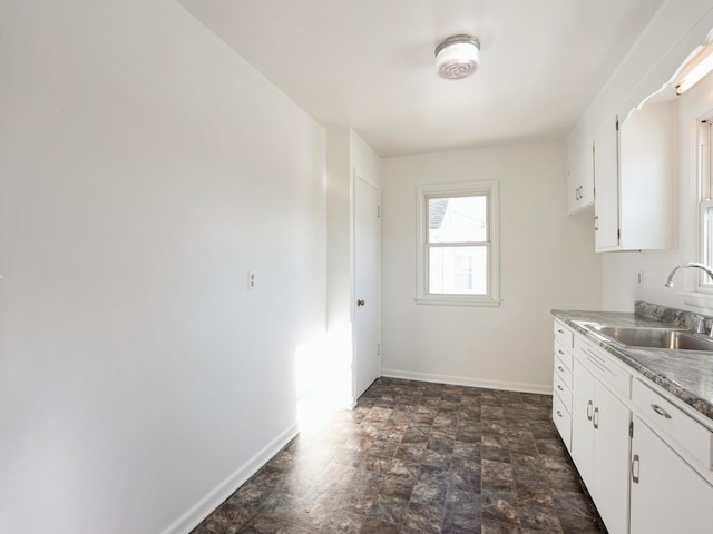 kitchen featuring white cabinetry and sink