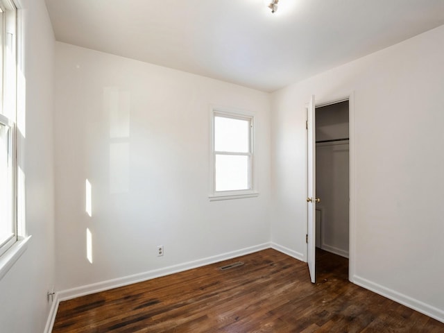 unfurnished bedroom featuring dark hardwood / wood-style floors and a closet