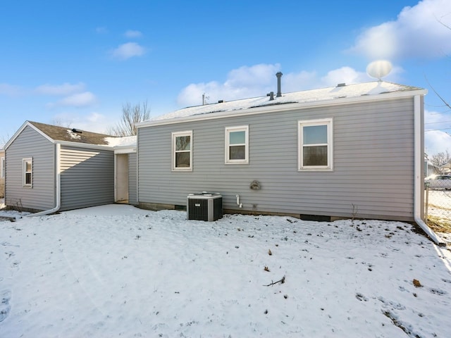 snow covered house featuring cooling unit