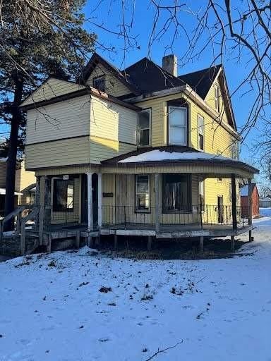 snow covered property featuring a porch