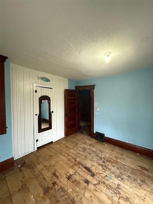 spare room with a textured ceiling and hardwood / wood-style flooring