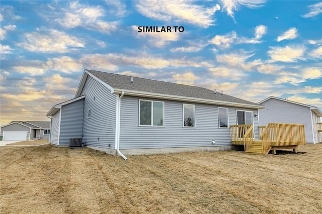 rear view of house with central AC unit, a yard, and a deck