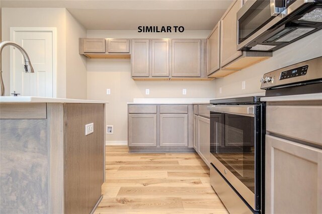 kitchen with sink, light hardwood / wood-style flooring, and stainless steel appliances