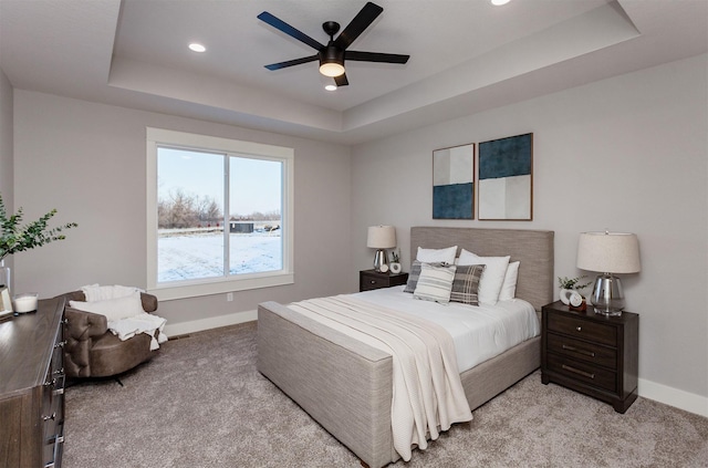 bedroom featuring a tray ceiling, ceiling fan, and light colored carpet