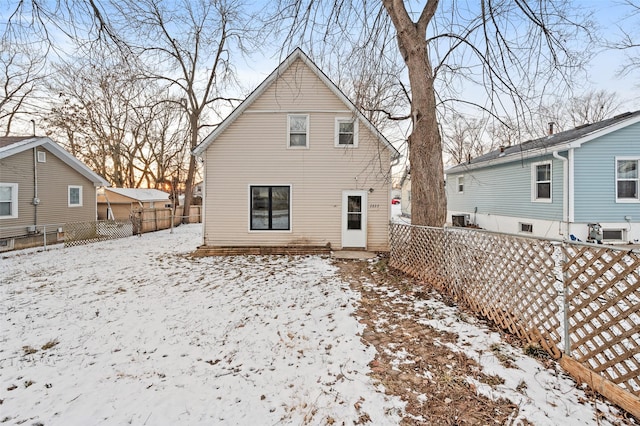 snow covered house with central air condition unit