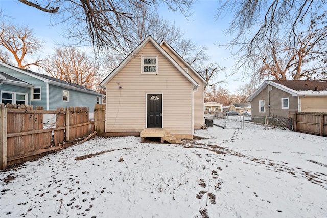 snow covered rear of property featuring cooling unit