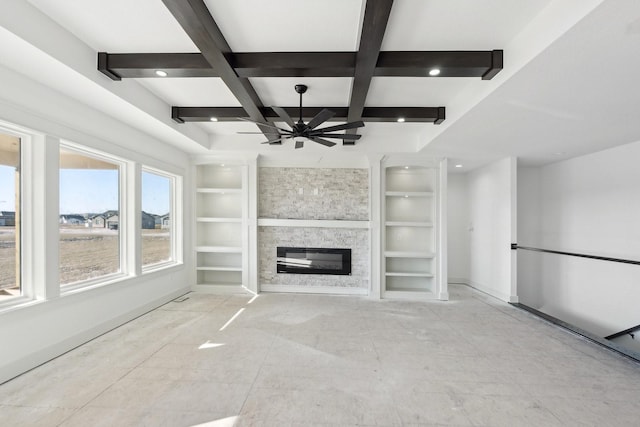 unfurnished living room featuring coffered ceiling, ceiling fan, built in features, beamed ceiling, and a fireplace