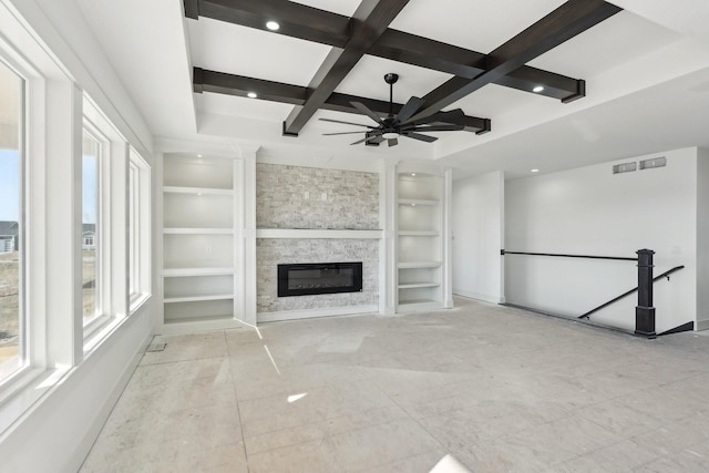 unfurnished living room with ceiling fan, coffered ceiling, built in features, beamed ceiling, and a fireplace