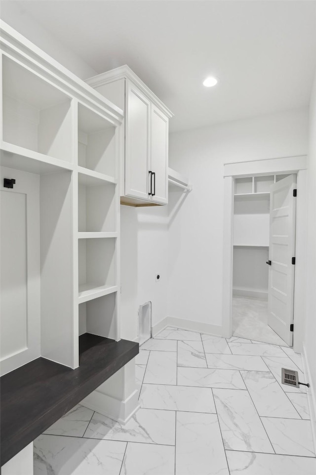 interior space with recessed lighting, baseboards, marble finish floor, cabinet space, and electric dryer hookup