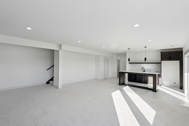 unfurnished living room featuring stairs, light carpet, baseboards, and recessed lighting