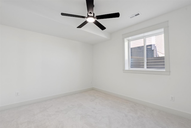 unfurnished room with light carpet, baseboards, visible vents, and a ceiling fan