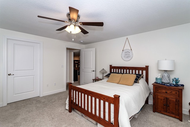 carpeted bedroom with ceiling fan and a textured ceiling