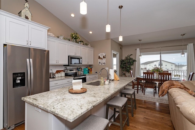 kitchen with pendant lighting, a kitchen island with sink, sink, and appliances with stainless steel finishes