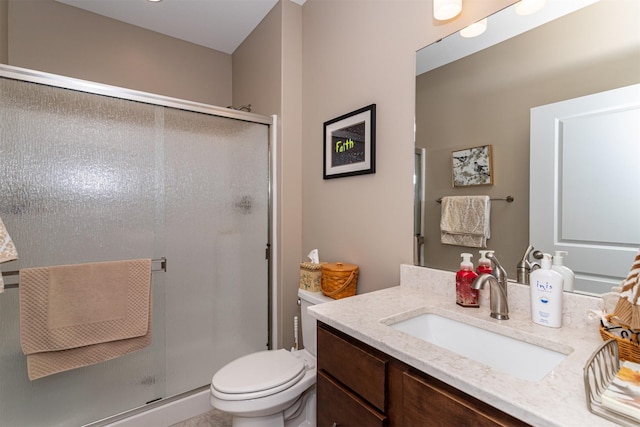 bathroom featuring vanity, an enclosed shower, and toilet