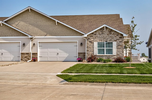 490 Bella Vista Ct, Huxley, IA 50124 - craftsman-style house with stone siding, driveway, roof with shingles, a front lawn, and an attached garage