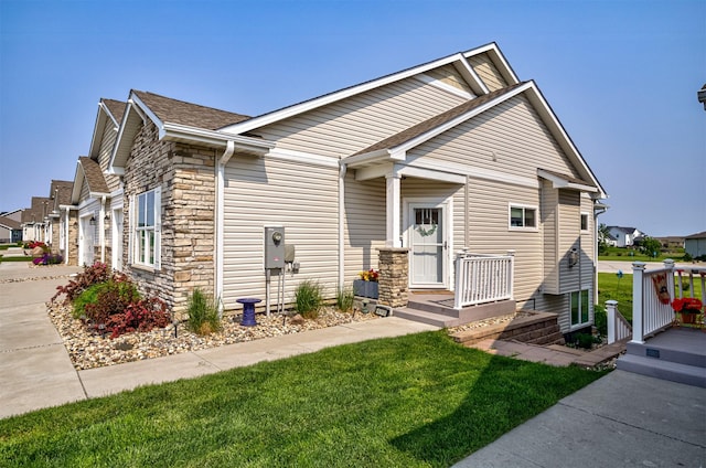 490 Bella Vista Ct, Huxley, IA 50124 - view of front of home with stone siding, concrete driveway, a front yard, and a shingled roof