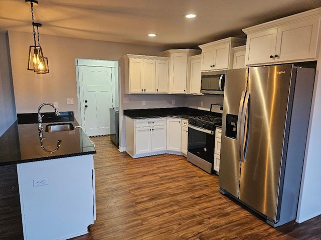 kitchen featuring hanging light fixtures, white cabinets, stainless steel appliances, and sink