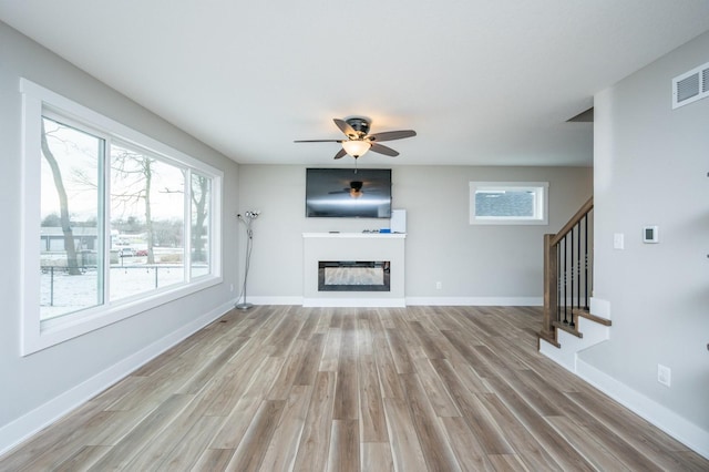 unfurnished living room with light hardwood / wood-style floors and ceiling fan