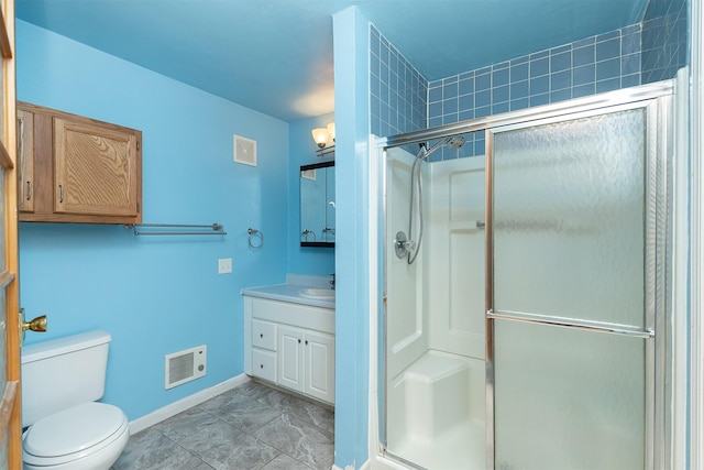 bathroom with vanity, toilet, and a shower with shower door