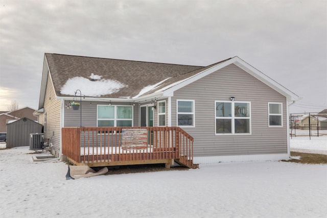 snow covered rear of property with a deck and central air condition unit