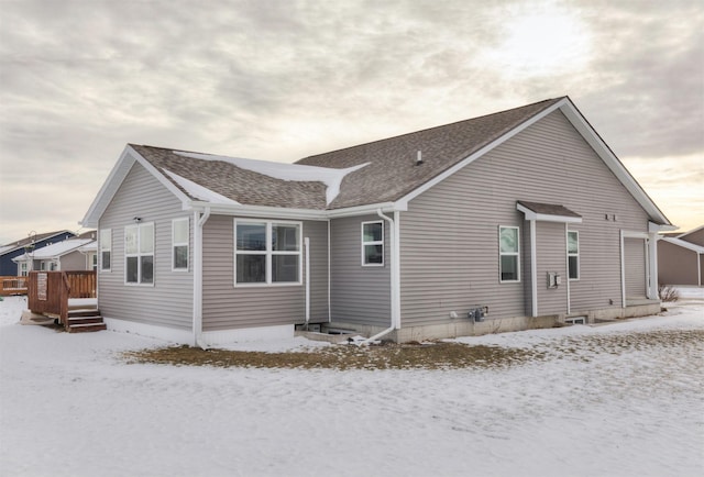 snow covered rear of property featuring a wooden deck