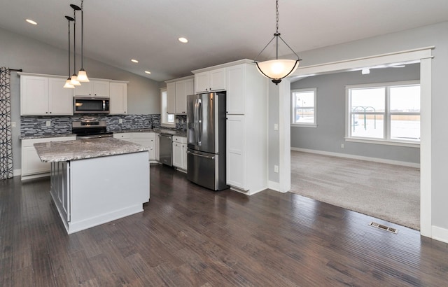 kitchen featuring a center island, white cabinetry, hanging light fixtures, and appliances with stainless steel finishes