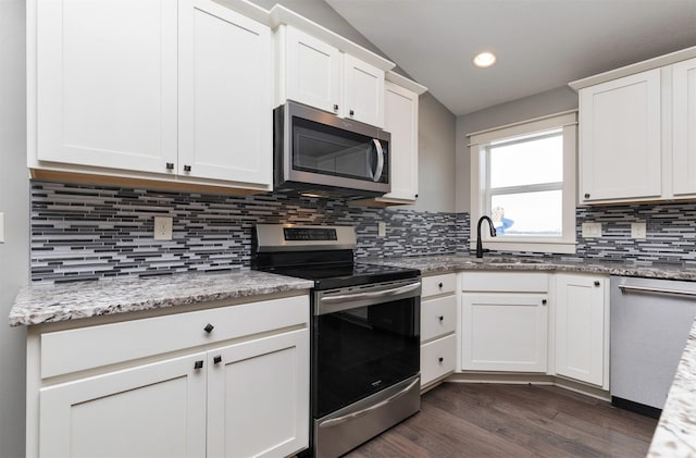 kitchen featuring white cabinets, sink, dark hardwood / wood-style floors, light stone counters, and stainless steel appliances