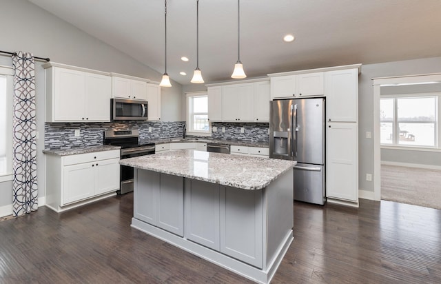 kitchen with a center island, white cabinets, lofted ceiling, and appliances with stainless steel finishes