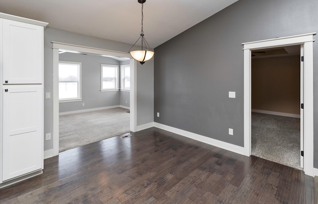 unfurnished dining area with dark hardwood / wood-style flooring and vaulted ceiling