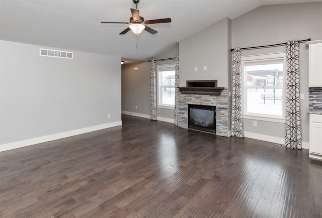 unfurnished living room featuring a fireplace, dark hardwood / wood-style floors, vaulted ceiling, and ceiling fan