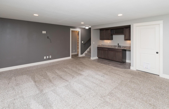 kitchen with light carpet, dark brown cabinets, and sink