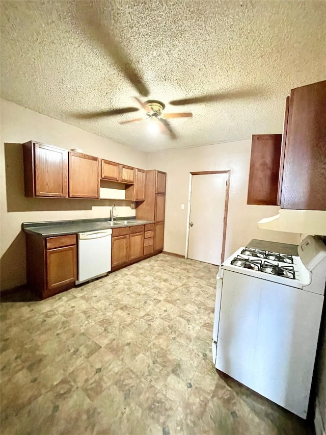 kitchen featuring a textured ceiling, white appliances, ceiling fan, and sink