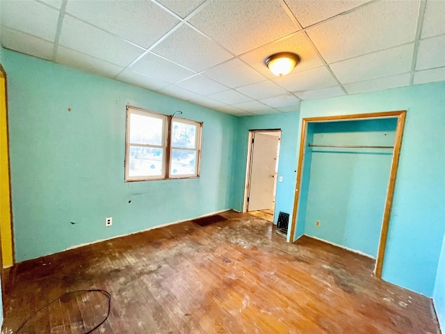 unfurnished bedroom with a paneled ceiling and a closet