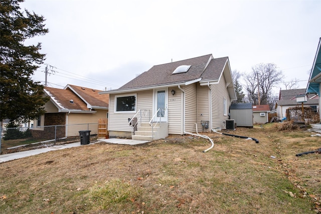 bungalow-style home featuring a front yard and central AC