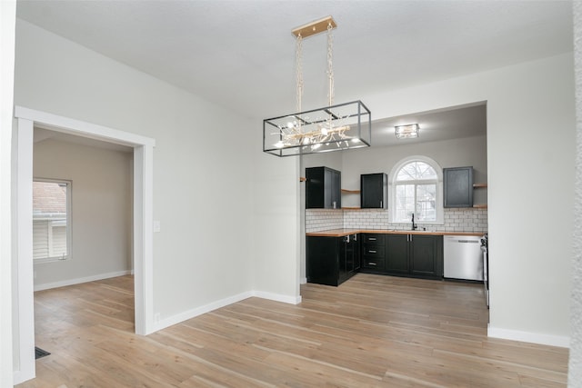 kitchen featuring decorative backsplash, light wood-type flooring, pendant lighting, dishwasher, and butcher block countertops