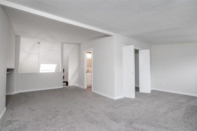 carpeted empty room featuring a textured ceiling