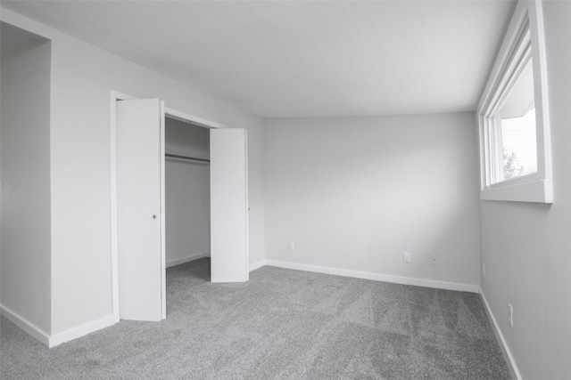 unfurnished bedroom featuring carpet flooring and a closet