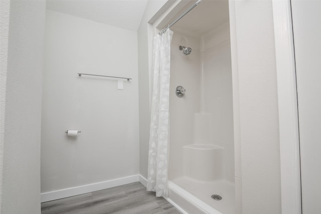 bathroom featuring a textured ceiling, hardwood / wood-style flooring, and walk in shower