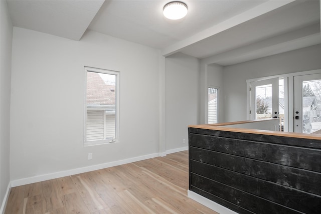 interior space with a healthy amount of sunlight, french doors, and light hardwood / wood-style flooring