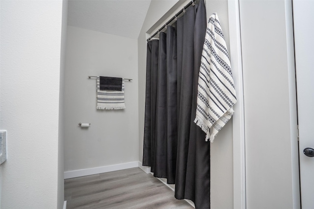 1141 Euclid Ave, Des Moines, IA 50313 - bathroom featuring wood finished floors, baseboards, and a shower with curtain