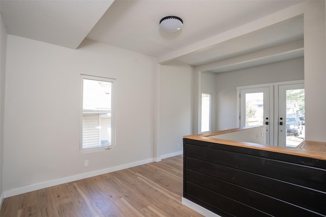 1141 Euclid Ave, Des Moines, IA 50313 - unfurnished room with light wood-type flooring, french doors, and baseboards