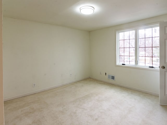 unfurnished room featuring light colored carpet