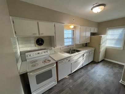 kitchen featuring white cabinets, dark hardwood / wood-style flooring, white appliances, and sink