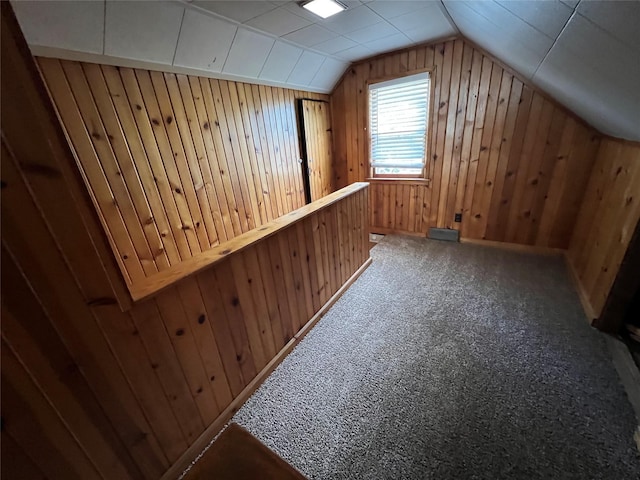 bonus room with carpet floors, vaulted ceiling, and wood walls