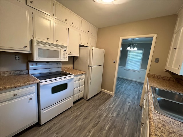 kitchen featuring sink, an inviting chandelier, dark hardwood / wood-style flooring, white appliances, and white cabinets