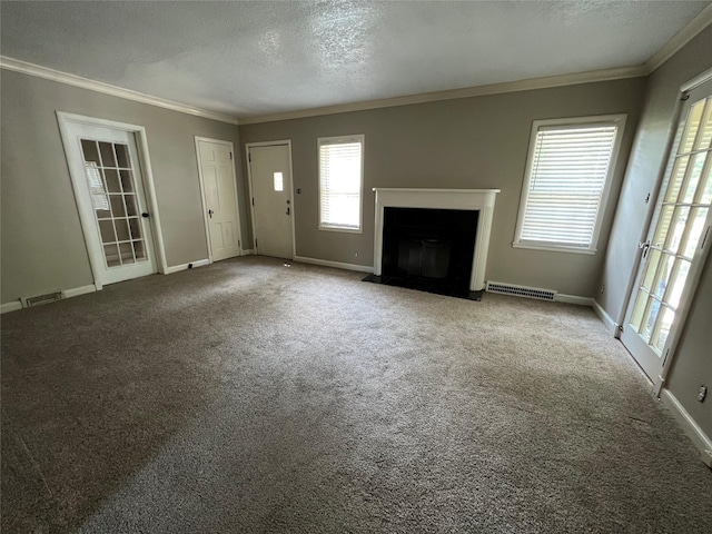 unfurnished living room featuring a textured ceiling, carpet floors, a wealth of natural light, and crown molding