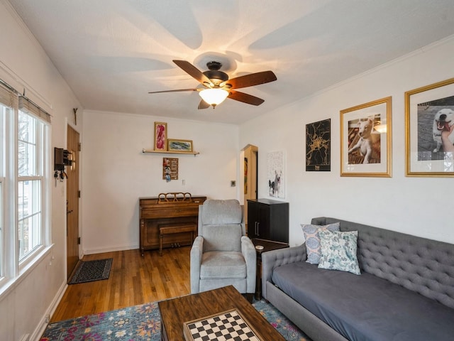 living room with light hardwood / wood-style floors, ceiling fan, and ornamental molding