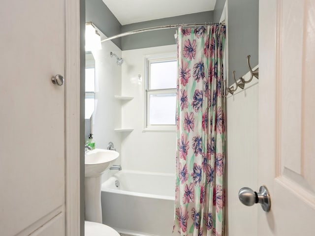 bathroom featuring toilet and shower / bathtub combination with curtain